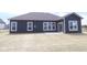 Exterior backyard featuring a patio and a spacious lawn with the house dark gray siding and white window trim at 4076 Berry Chase Blvd, Greenwood, IN 46143