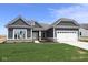 Charming single-story home with a manicured lawn and two-car garage with gray facade and white trim details at 4076 Berry Chase Blvd, Greenwood, IN 46143