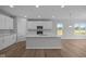 Bright kitchen with an island, white cabinets, modern appliances, and wood flooring at 4076 Berry Chase Blvd, Greenwood, IN 46143
