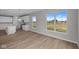Open-concept kitchen featuring an island, white cabinets, wood flooring, and natural light at 4076 Berry Chase Blvd, Greenwood, IN 46143