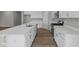 Contemporary kitchen with an island, white cabinets, modern appliances, and wood-style flooring at 4076 Berry Chase Blvd, Greenwood, IN 46143