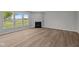 Spacious living room with a fireplace, wood flooring, and large windows overlooking the yard at 4076 Berry Chase Blvd, Greenwood, IN 46143