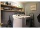 Functional laundry room with washer, dryer, and shelving for storage at 4644 N Ritter Ave, Indianapolis, IN 46226