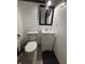 A well-lit bathroom features a toilet, vanity with a white countertop, and a black-framed mirror at 4718 Tempe Ct, Indianapolis, IN 46241