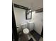 A well-lit bathroom features a toilet, vanity with a white countertop, and a black-framed mirror at 4718 Tempe Ct, Indianapolis, IN 46241