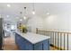 Kitchen island with quartz countertop and drop lighting leads to bright and airy living space at 4725 Boulevard Pl, Indianapolis, IN 46208