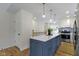 Bright kitchen featuring a blue island with a white countertop and modern pendant lighting at 4725 Boulevard Pl, Indianapolis, IN 46208