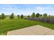 Green backyard featuring a patio, lawn, and a wooden fence, providing a private outdoor space at 4752 Chip Shot Ln, Indianapolis, IN 46235