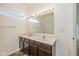 Bright bathroom with double sinks, dark cabinetry and a large vanity mirror at 4752 Chip Shot Ln, Indianapolis, IN 46235