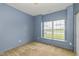 Bedroom showcasing blue walls, carpet, and window letting in ample natural light at 4752 Chip Shot Ln, Indianapolis, IN 46235