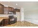 Open-concept kitchen featuring dark cabinets, black appliances, and lots of countertop space at 4752 Chip Shot Ln, Indianapolis, IN 46235