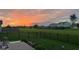 Beautiful backyard with sunset view, black metal fence, green grass, and neighborhood view at 505 Shallowroot Ln, Sheridan, IN 46069
