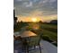 Relax on the patio with a table and chairs, overlooking the backyard at sunset at 505 Shallowroot Ln, Sheridan, IN 46069