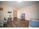 Spacious bedroom with wood floors, featuring a toy kitchen and bookshelf at 505 Shallowroot Ln, Sheridan, IN 46069