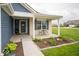 Inviting front porch with brick accents, charming front door, and manicured landscaping at 505 Shallowroot Ln, Sheridan, IN 46069