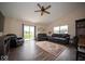 Spacious living room with hardwood floors, a ceiling fan, a patio door, and large windows at 505 Shallowroot Ln, Sheridan, IN 46069