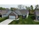 Aerial view of a brick home with well-manicured lawn, and long driveway at 509 Tulip Tree Dr, Lapel, IN 46051