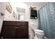 Well-lit bathroom with a dark wood vanity, white toilet, and stylish shower curtain at 509 Tulip Tree Dr, Lapel, IN 46051