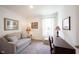 Comfortable carpeted bedroom with sofa, desk, lamps, and a sunlit window at 509 Tulip Tree Dr, Lapel, IN 46051