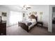 Well-lit bedroom with classic dark wood furniture, ceiling fan, and plush carpeting at 509 Tulip Tree Dr, Lapel, IN 46051