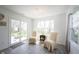 Sunlit sitting room boasts tile floors, two windows, sliding glass door and neutral decor at 509 Tulip Tree Dr, Lapel, IN 46051