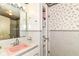 Quaint bathroom featuring a pink sink, floral wallpaper, and tiled walls at 5101 Dickson Rd, Indianapolis, IN 46226