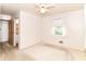 Bright bedroom featuring a ceiling fan, a window with curtains and access to the bathroom at 5101 Dickson Rd, Indianapolis, IN 46226