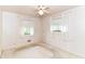 Bright bedroom with two windows adorned with white curtains and a ceiling fan at 5101 Dickson Rd, Indianapolis, IN 46226