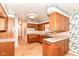 Cozy kitchen with wood cabinets, laminate countertops, stainless steel dishwasher, and floral wallpaper accents at 5101 Dickson Rd, Indianapolis, IN 46226