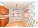 Kitchen/dining nook with wood cabinets, laminate counters, floral wallpaper, and wood flooring at 5101 Dickson Rd, Indianapolis, IN 46226