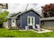 Backyard with a patio, lounge chairs, grill, and blue siding house, a great outdoor space at 5241 Guilford Ave, Indianapolis, IN 46220