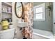 Charming bathroom with a tub and shower, patterned shower curtain, and built-in shelving at 5241 Guilford Ave, Indianapolis, IN 46220