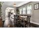 Open dining room featuring hardwood floors, large windows with natural light, and an arched entryway to the kitchen at 5241 Guilford Ave, Indianapolis, IN 46220