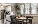 Inviting dining room with a wood table, natural lighting, and an arched entryway to a well-lit modern kitchen at 5241 Guilford Ave, Indianapolis, IN 46220