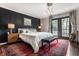 Spacious main bedroom featuring a king-sized bed, decorative rug, a dark accent wall, and French doors at 5241 Guilford Ave, Indianapolis, IN 46220