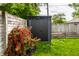 A modern shed is nestled in the yard, surrounded by lush greenery and a vibrant flower bush at 5241 Guilford Ave, Indianapolis, IN 46220
