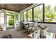 Relaxing sunroom with large windows offering serene views, a table with chairs, and comfortable decor at 5241 Guilford Ave, Indianapolis, IN 46220