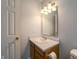 A half bathroom features a door to the outside, vanity with sink and storage, and modern light fixture at 5351 Eel River Ct, Indianapolis, IN 46221