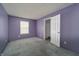 A sunlit bedroom with purple walls and neutral carpeting provides a calming atmosphere at 5351 Eel River Ct, Indianapolis, IN 46221