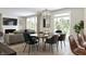 Open-concept dining and living area with hardwood floors and many windows offering natural light at 5774 Cloister Ln, McCordsville, IN 46055