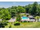 Aerial view showcasing community pool, playground, tennis court, and mature trees at 5800 Lawrence Dr, Indianapolis, IN 46226