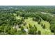 Stunning aerial view of golf course, pool, and tennis courts surrounded by lush trees and picturesque landscape at 5800 Lawrence Dr, Indianapolis, IN 46226