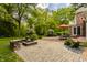 Spacious backyard patio with outdoor seating and fire pit, surrounded by mature trees at 5800 Lawrence Dr, Indianapolis, IN 46226