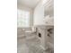 This bathroom features stylish tile flooring, a large window, and a classic white pedestal sink at 5800 Lawrence Dr, Indianapolis, IN 46226