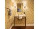 Charming powder room boasting bird wallpaper, decorative sconces, and a unique pedestal sink at 5800 Lawrence Dr, Indianapolis, IN 46226