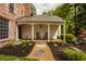 Cozy covered porch with rocking chairs, complemented by stone pathway and garden accents at 5800 Lawrence Dr, Indianapolis, IN 46226