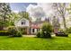 A charming two-story brick and white home with outdoor patio and lush landscaping at 5800 Lawrence Dr, Indianapolis, IN 46226