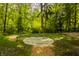 Tranquil outdoor space with a circular stone design, surrounded by lush greenery and mature trees at 5800 Lawrence Dr, Indianapolis, IN 46226