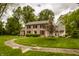Traditional brick home featuring classic architecture, a welcoming porch, and a beautifully landscaped yard at 5800 Lawrence Dr, Indianapolis, IN 46226