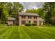 Elegant brick home with black shutters, surrounded by a well-maintained lawn and mature trees at 5800 Lawrence Dr, Indianapolis, IN 46226